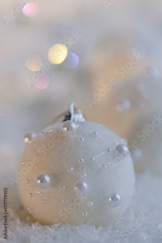 Christmas beautiful gray blurred background with white balls with pearls and colored bokeh. Shallow depth of field