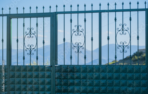 Metal Green gate near beautiful estate on sunny day in Saranda Albania. Victorian style gate