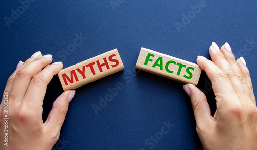 Facts or Myths symbol. Concept word Facts or Myths on wooden blocks. Businessman hand. Beautiful deep blue background. Business and Facts or Myths concept. Copy space photo