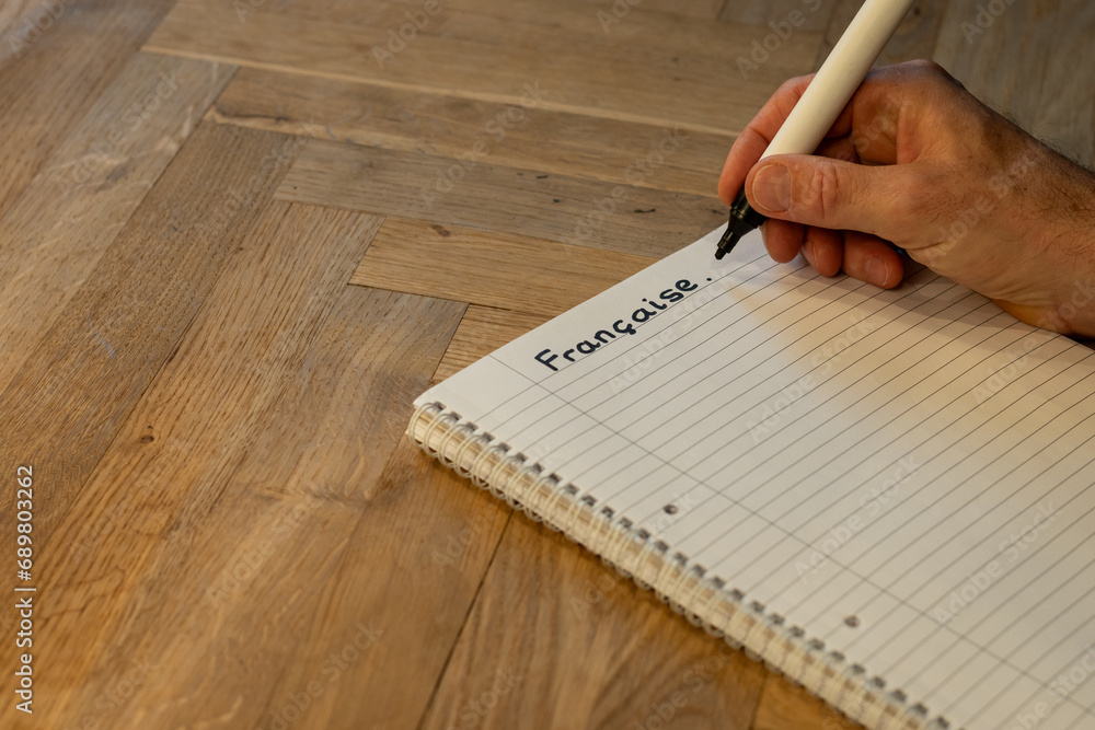 Blank notepad in class on wooden desk for student learning French