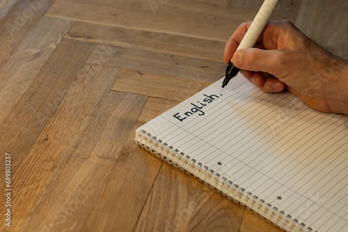 Blank notepad in class on wooden desk for student learning English written language. Language subject for adult learning with handwritten notes and writing exercises for personal development photo