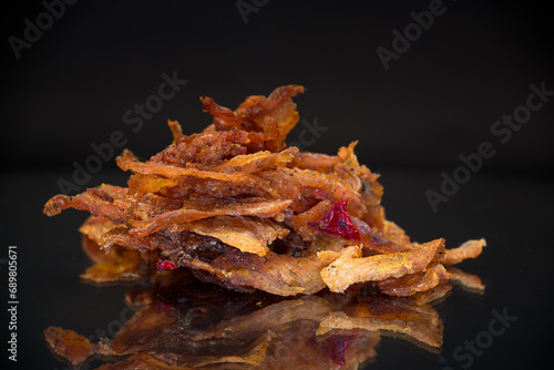 Φωτογραφία handful of dried meat marinated with spices, isolated on a black background