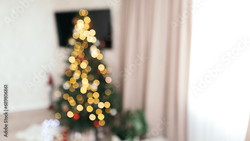 Blur bokeh defocused cozy flat apartment photo studio room green Christmas Tree gifts presents garlands, candles decorated toys balls interior New Year lights glowing 