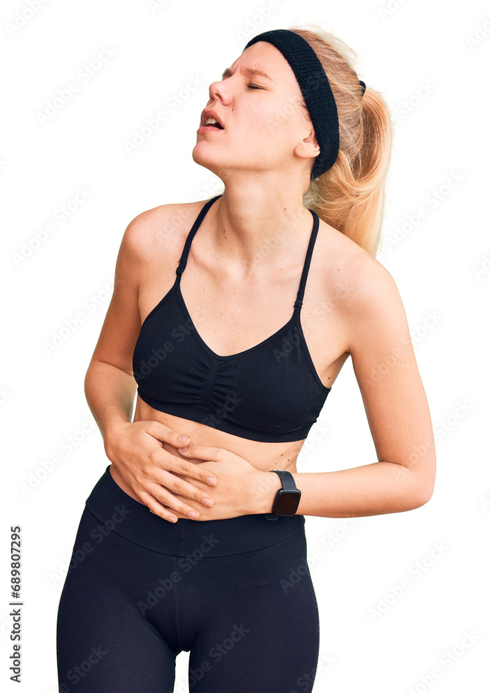 Young beautiful blonde woman wearing sportswear with hand on stomach because nausea, painful disease feeling unwell. ache concept. Young beautiful blonde woman wearing sportswear with hand on stomach because nausea, painful disease feeling unwell. ache concept.