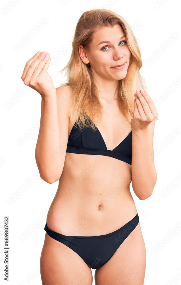 Young beautiful blonde woman wearing bikini doing money gesture with hands, asking for salary payment, millionaire business Young beautiful blonde woman wearing bikini doing money gesture with hands, asking for salary payment, millionaire business