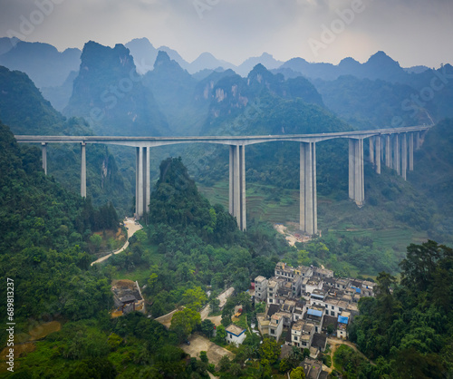 Aerial view of a high suspended highway bridge near a small village, Jingxi City, Guangxi Zhuang Autonomous Region, China. photo