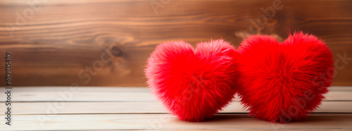 Two fluffy red fur hearts, puffy for Valentine's Day, on a wooden background, concept of love, Valentine's Day, wedding day.