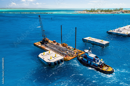 Aerial View of pier construction in the Bahamas. The tug boat, Miss Ashley, supports a barge and crane alongside the pier, Berry Islands, The Bahamas. photo