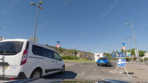 First person view, FPV, from dashcam of car driving along the Algarve Coast in Portugal towards Albufeira, driving on the highway. Road trip video in POV, with blue sky photo