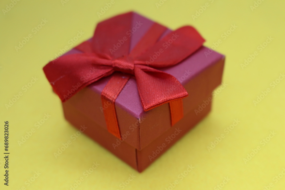 A red bow on a yellow surface A red bow on a yellow surface