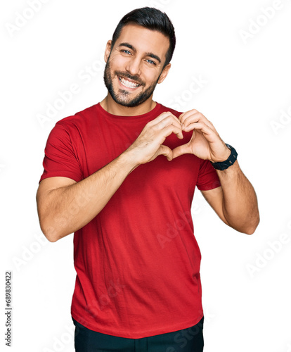 Young hispanic man wearing casual clothes smiling in love showing heart symbol and shape with hands. romantic concept.