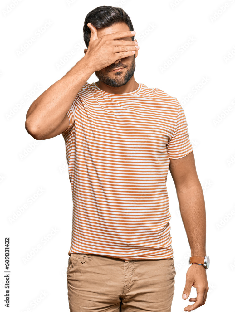 Handsome hispanic man wearing casual clothes covering eyes with hand, looking serious and sad. sightless, hiding and rejection concept Handsome hispanic man wearing casual clothes covering eyes with hand, looking serious and sad. sightless, hiding and rejection concept