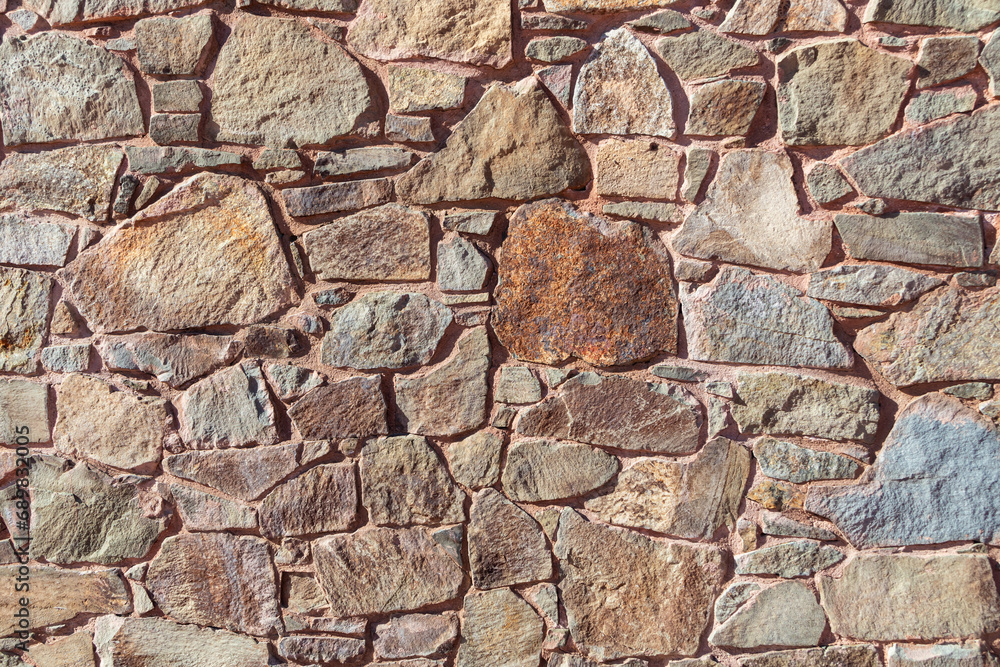Stone wall texture. The background of the wall is made of stones of different sizes Stone wall texture. The background of the wall is made of stones of different sizes