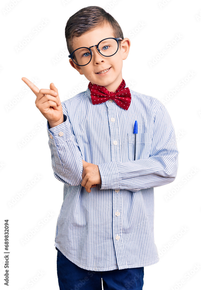 Cute blond kid wearing nerd bow tie and glasses smiling happy pointing with hand and finger to the side Cute blond kid wearing nerd bow tie and glasses smiling happy pointing with hand and finger to the side