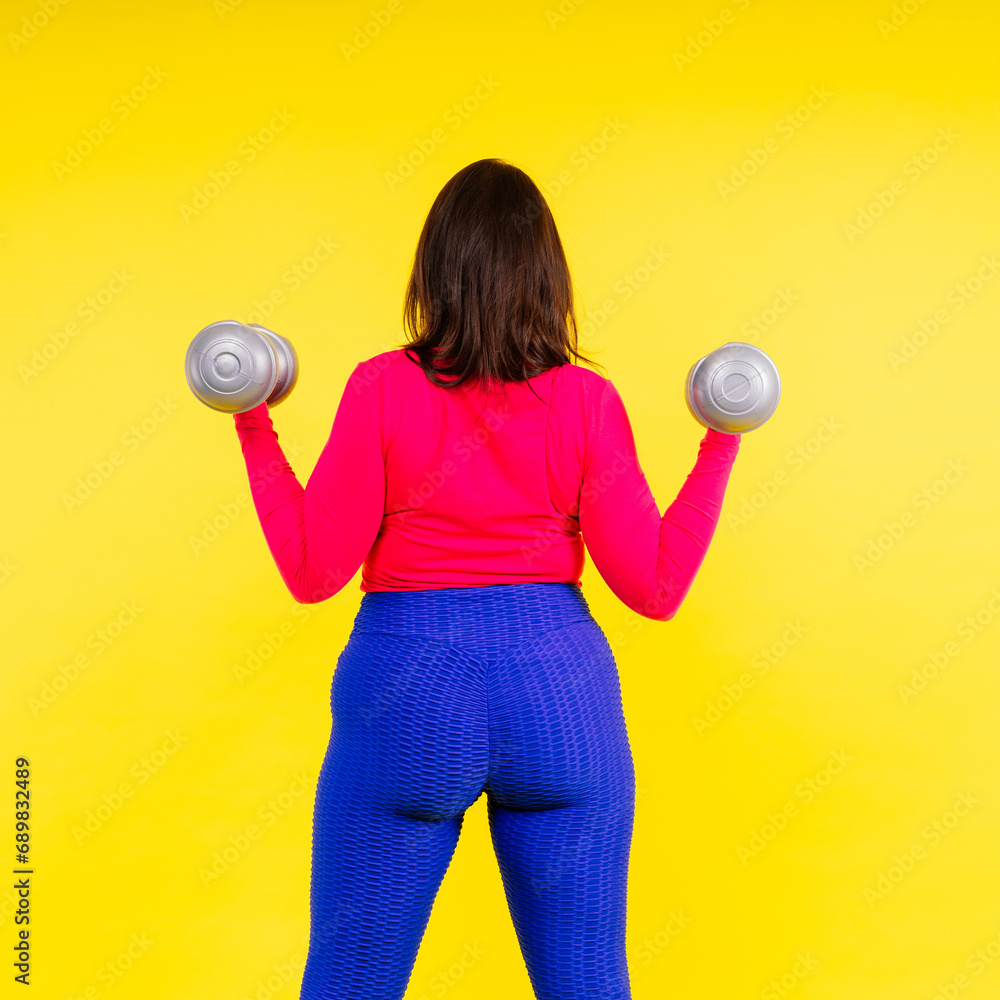 Young smiling happy chubby overweight plus size big fat fit woman warm up training hold dumbbells Young smiling happy chubby overweight plus size big fat fit woman warm up training hold dumbbells