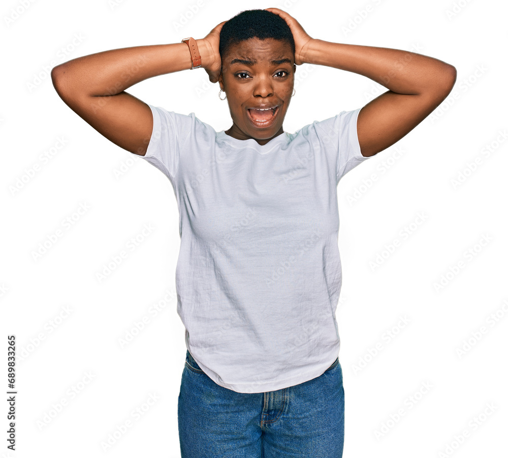 Young african american woman wearing casual white t shirt crazy and scared with hands on head, afraid and surprised of shock with open mouth Young african american woman wearing casual white t shirt crazy and scared with hands on head, afraid and surprised of shock with open mouth