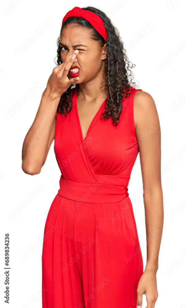 Young african american girl wearing elegant and sexy look smelling something stinky and disgusting, intolerable smell, holding breath with fingers on nose. bad smell Young african american girl wearing elegant and sexy look smelling something stinky and disgusting, intolerable smell, holding breath with fingers on nose. bad smell