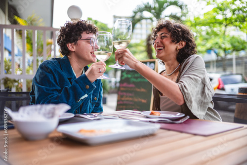 Namoradas brindando em um restaurante ao ar livre. photo