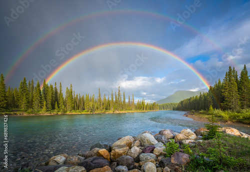 View of a river crossing the Banff National Park with the rainbow in Alberta region of Canada. photo