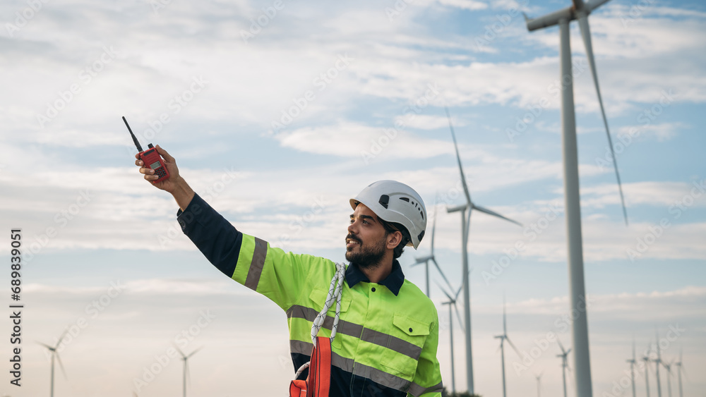 Service engineers checking system of windmill at wind farm. Wind turbines generate electricity. Clean and Renewable energy concept. Service engineers checking system of windmill at wind farm. Wind turbines generate electricity. Clean and Renewable energy concept.