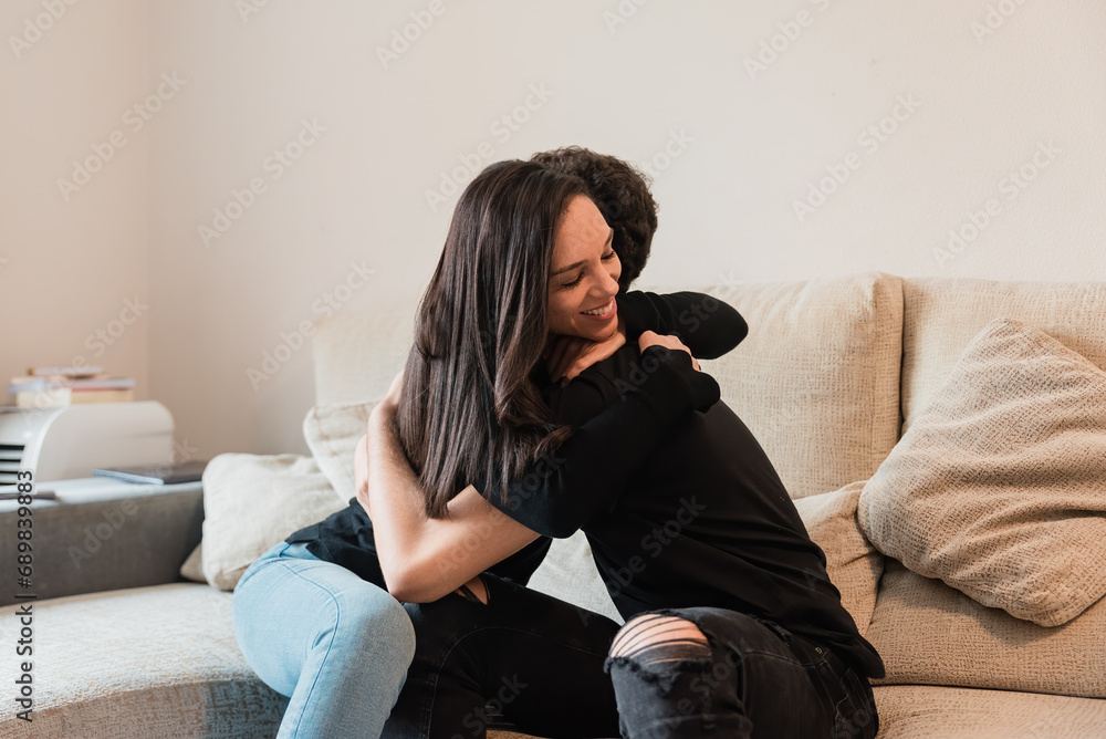 Obraz premium Soulmates hugging on sofa in living room