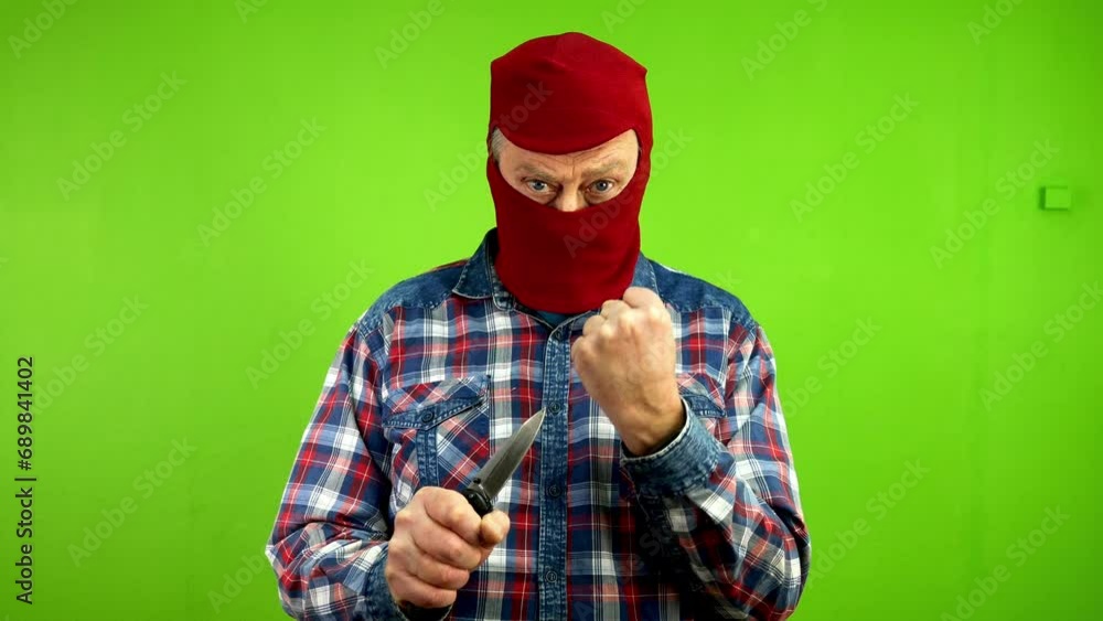 Dangerous criminal in mask threatening with knife, shake fist scaring someone. Dangerous criminal in mask threatening with knife, shake fist scaring someone.
