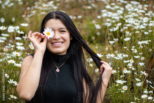 Mujer atractiva cubriendo los ojos con ramas de flores durante la primavera photo
