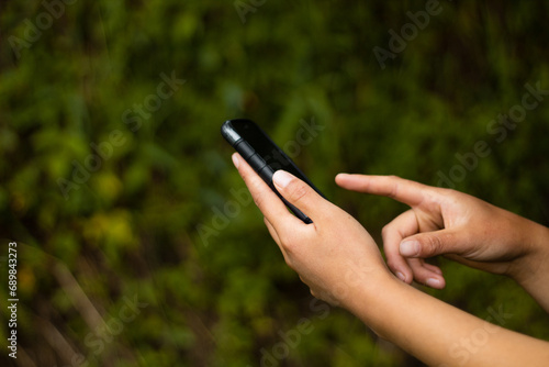 Empresaria usando teléfono celular, de mano sosteniendo el teléfono con fondo de desenfoque, navegando por internet con dispositivo celular