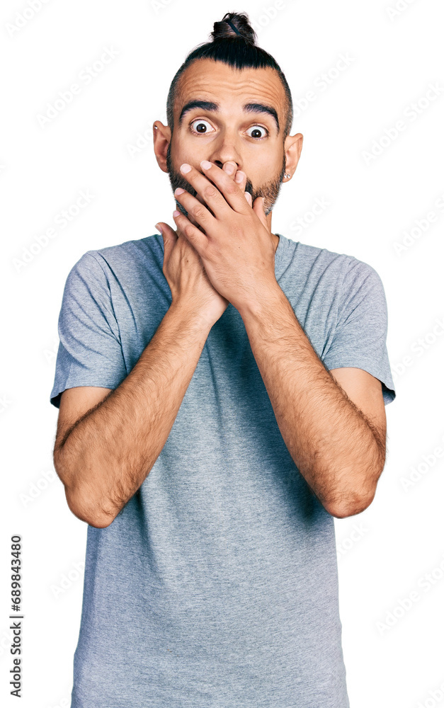 Hispanic man with ponytail wearing casual grey t shirt shocked covering mouth with hands for mistake. secret concept. Hispanic man with ponytail wearing casual grey t shirt shocked covering mouth with hands for mistake. secret concept.