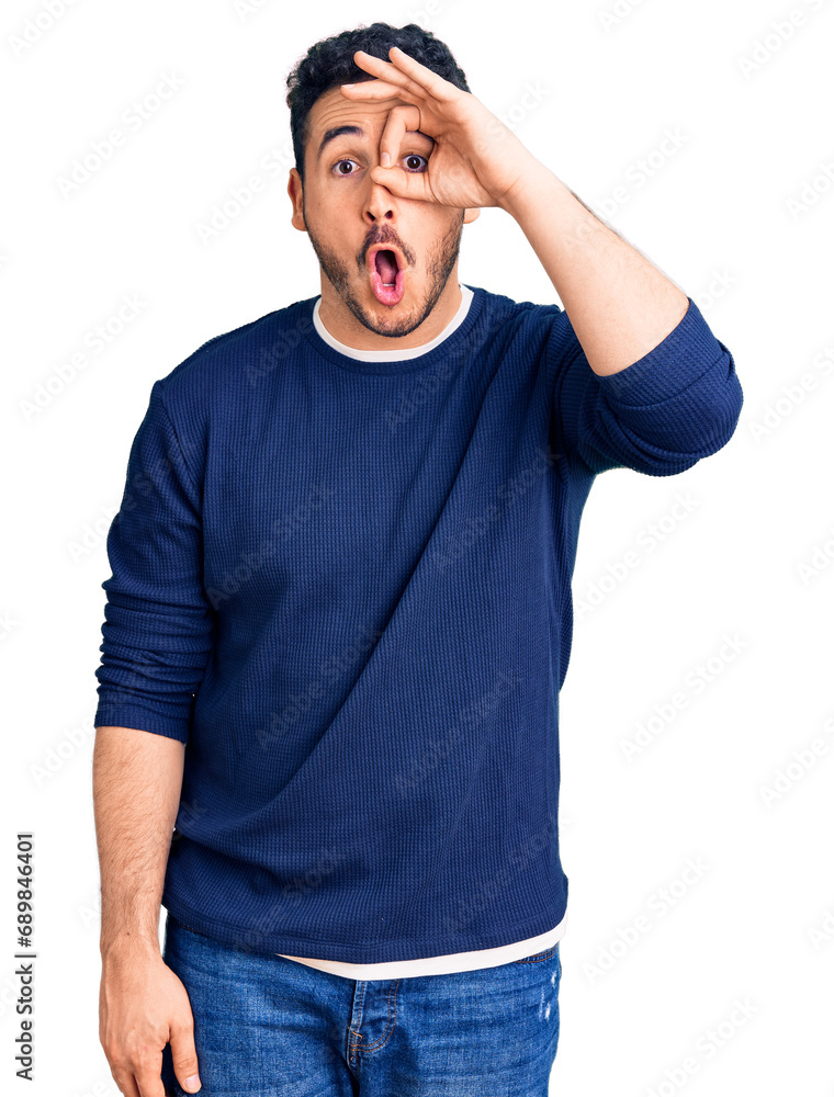 Young hispanic man wearing casual clothes doing ok gesture shocked with surprised face, eye looking through fingers. unbelieving expression. Young hispanic man wearing casual clothes doing ok gesture shocked with surprised face, eye looking through fingers. unbelieving expression.