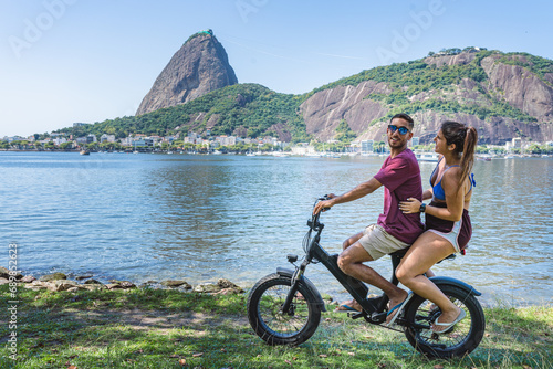 Young couple having fun riding bicycle along the coast.