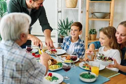 child family lunch food woman meal eating mother dinner man father together happy daughter home table dining parent grandparent