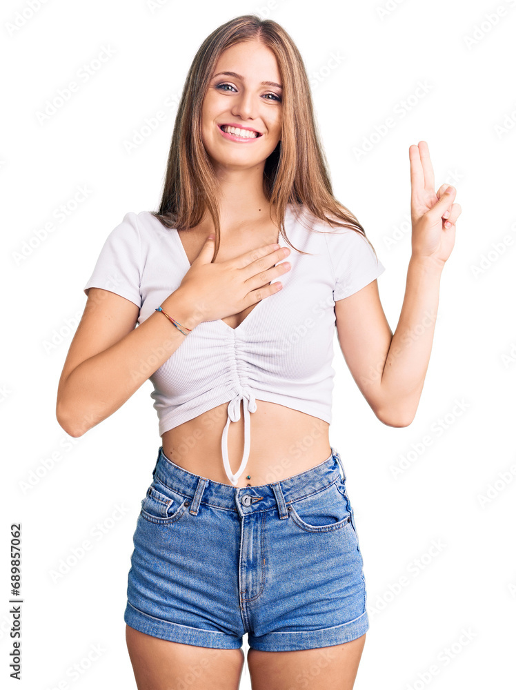 Young beautiful blonde woman wearing casual white tshirt smiling swearing with hand on chest and fingers up, making a loyalty promise oath Young beautiful blonde woman wearing casual white tshirt smiling swearing with hand on chest and fingers up, making a loyalty promise oath
