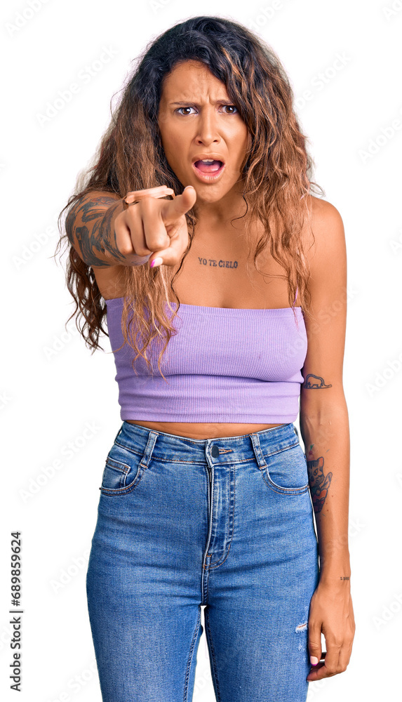 Young hispanic woman with tattoo wearing casual clothes pointing displeased and frustrated to the camera, angry and furious with you Young hispanic woman with tattoo wearing casual clothes pointing displeased and frustrated to the camera, angry and furious with you