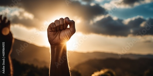 Clenched Fist In The Air. Male hand raises clenched fist of solidarity. Protester holding hand up over dramatic sky. hand rising up, arabian or middle east background. Triumph or defiance, against sky