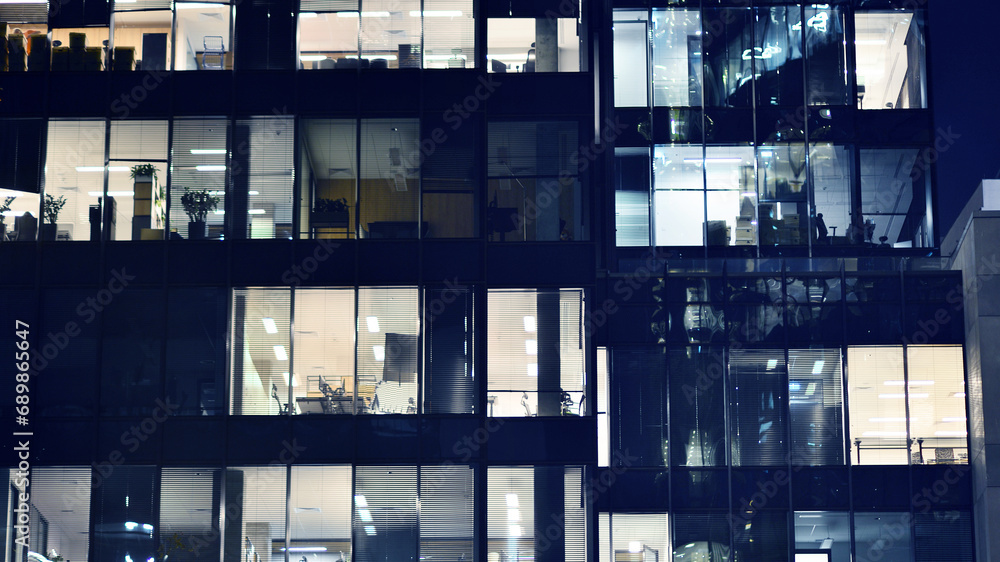 Fragment of the glass facade of a modern corporate building at night. Modern glass office in city. Fragment of the glass facade of a modern corporate building at night. Modern glass office in city.
