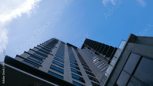 Close-up bottom view of office building, hotel, condominium, apartment window. with clouds in the sky Reflection and perspective modern architecture sky