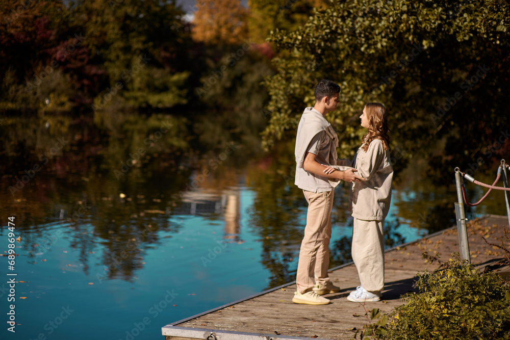 A happy couple in love in casual clothes travel together, hike and have fun in the fall forest on a weekend in nature in autumn outdoors, selective focus. COUPLE LOVE STORY park pond lake. Handsome A happy couple in love in casual clothes travel together, hike and have fun in the fall forest on a weekend in nature in autumn outdoors, selective focus. COUPLE LOVE STORY park pond lake. Handsome