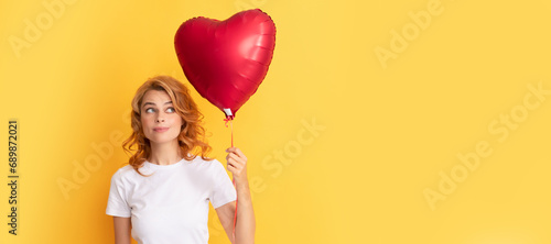 pondering redhead girl with love heart balloon. be my valentine. Beautiful woman isolated face portrait, banner with mock up copy space.