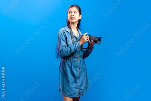 Photography Portrait of an attractive lovely Indian girl with a digital camera looking upwar
