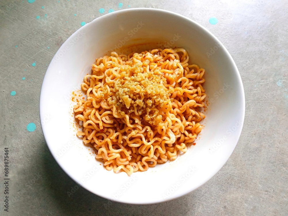 bowl of noodles. Instant boiled noodles in a white bowl on a gray background under the shade of sunlight. fried noodles. Instant boiled noodles with crunchy topping. simple instant noodles bowl of noodles. Instant boiled noodles in a white bowl on a gray background under the shade of sunlight. fried noodles. Instant boiled noodles with crunchy topping. simple instant noodles
