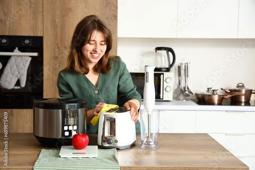 Young woman cleaning electr...