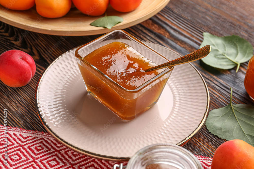 Glass bowl with sweet apricot jam on wooden background Glass bowl with sweet apricot jam on wooden background