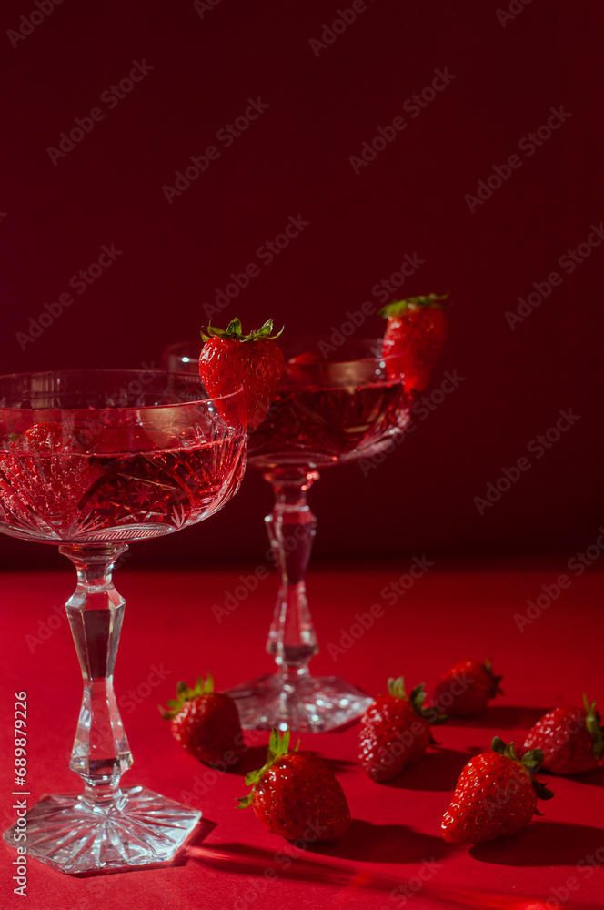 Obraz premium Two&nbsp;glasses&nbsp;of&nbsp;rose&nbsp;sparkling&nbsp;wine&nbsp;on&nbsp;red&nbsp;background&nbsp;romantic&nbsp;valentine's&nbsp;day&nbsp;concept