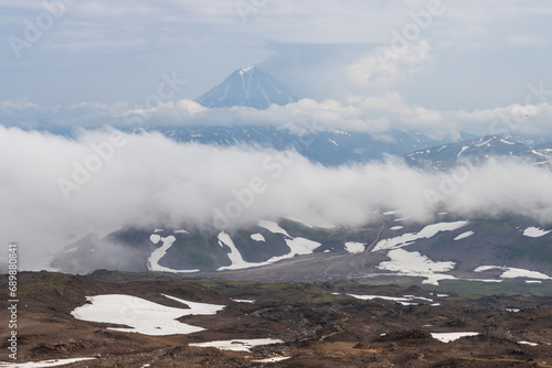 View from Gorely volcano to Vilyuchinsky volcano, Kamchatka Territory, Russia. Mountain landscape. Travel, tourism and hiking on the Kamchatka Peninsula. Beautiful nature of the Russian Far East. photo