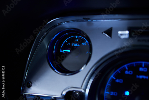 Dashboard of an illuminated sports car. Gas, oil, speed indicator.