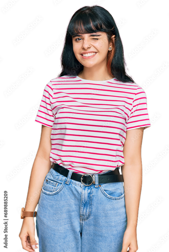 Young hispanic girl wearing casual clothes winking looking at the camera with sexy expression, cheerful and happy face. Young hispanic girl wearing casual clothes winking looking at the camera with sexy expression, cheerful and happy face.