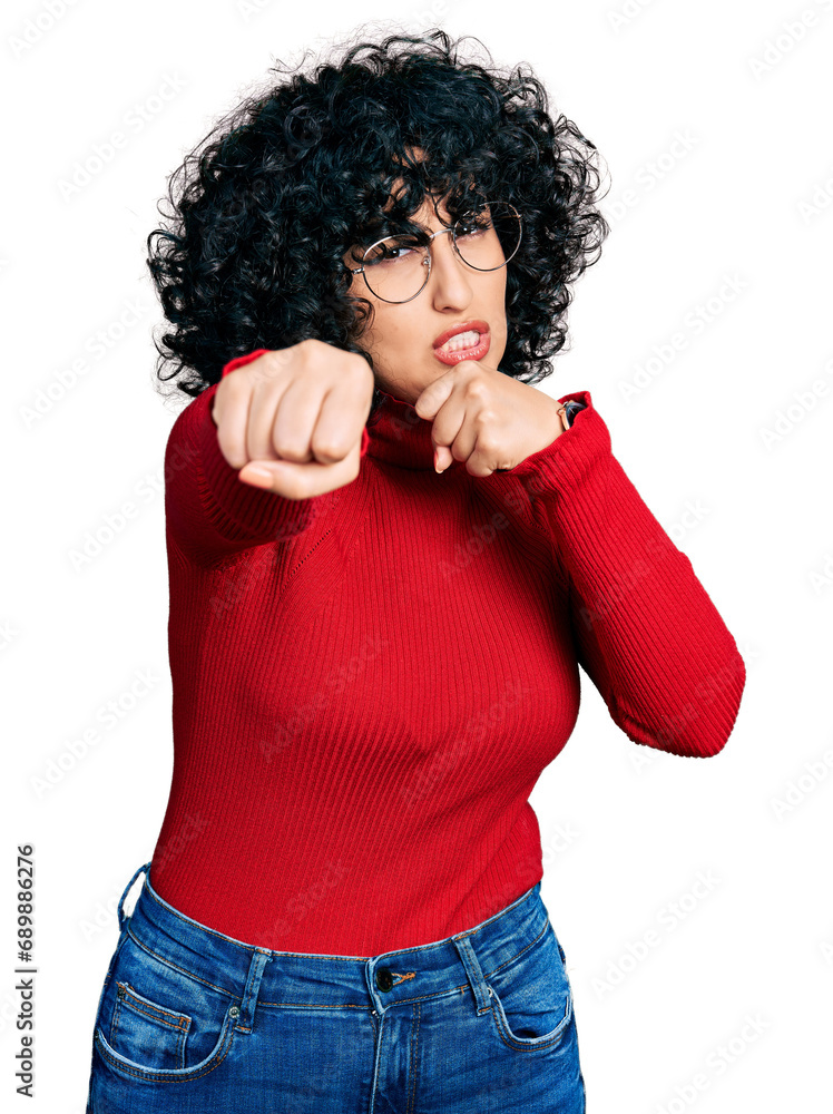 Young middle east girl wearing casual clothes and glasses punching fist to fight, aggressive and angry attack, threat and violence Young middle east girl wearing casual clothes and glasses punching fist to fight, aggressive and angry attack, threat and violence