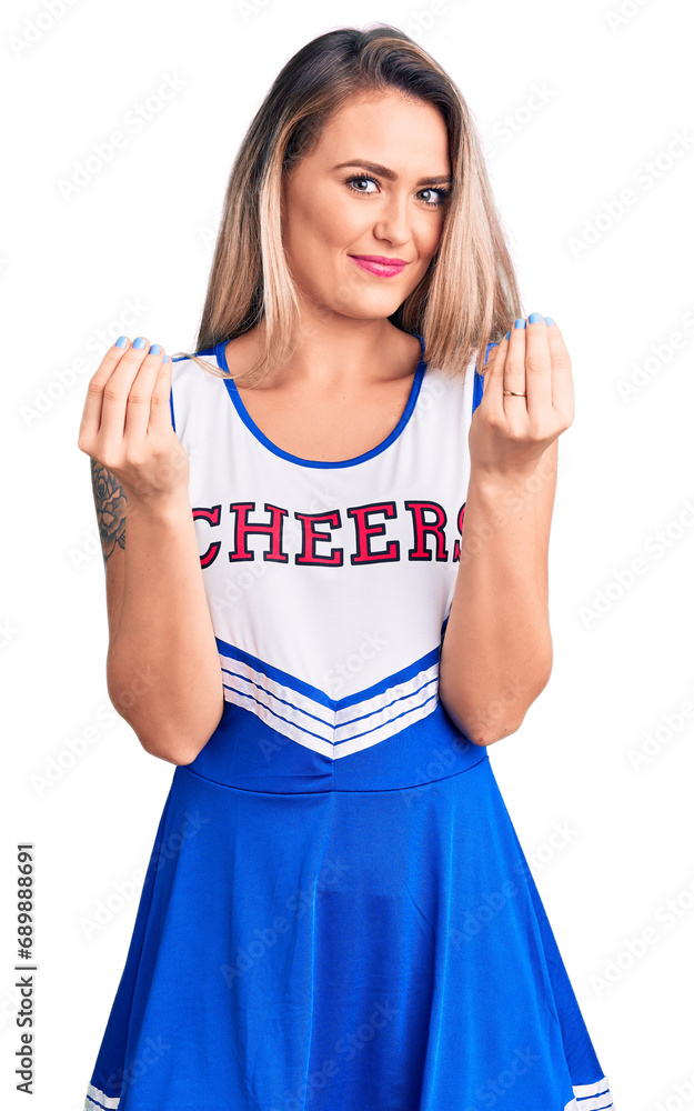 Fototapeta premium Young beautiful blonde woman wearing cheerleader uniform doing money gesture with hands, asking for salary payment, millionaire business