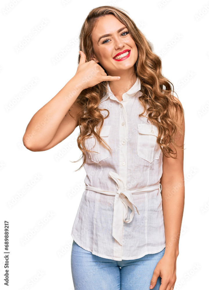 Young blonde girl wearing casual clothes smiling doing phone gesture with hand and fingers like talking on the telephone. communicating concepts. Young blonde girl wearing casual clothes smiling doing phone gesture with hand and fingers like talking on the telephone. communicating concepts.